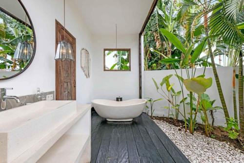 bagno con vasca bianca e grande specchio di Villa Ikebana - Trendy 5BR Spacious Villa with Rice Field Views, Large Pool, and 5 Minutes to Canggu a Kerobokan