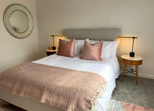 メルボルンにあるTreetops in Toorak 2br midcentury entire apartmentのベッドルーム1室(ピンクの枕と鏡付きのベッド1台付)