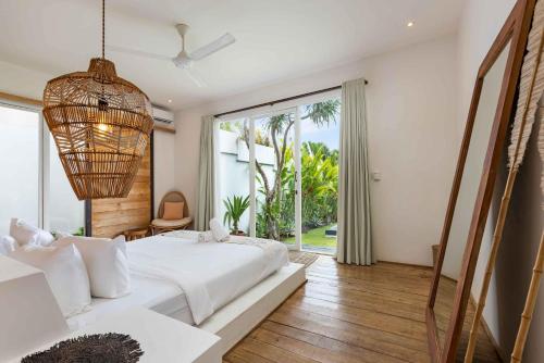 una camera da letto con un letto grande e una grande finestra di Villa Ikebana - Trendy 5BR Spacious Villa with Rice Field Views, Large Pool, and 5 Minutes to Canggu a Kerobokan