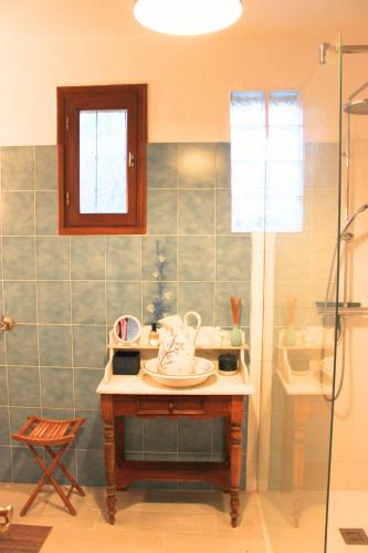 La salle de bains est pourvue d'une table, d'un lavabo et d'une douche. dans l'établissement Maison Familiale Querciolo Proche des plages, à Sorbo-Ocagnano