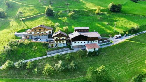 an aerial view of a house on a green hill at Schaidreithof in Grossarl