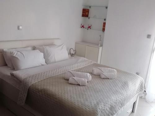 a white bedroom with a bed with two pillows on it at Elite Home in Polýkastron