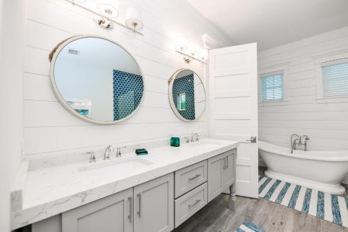 bagno con 2 lavandini, vasca e specchio di Freckled Fin ad Anna Maria