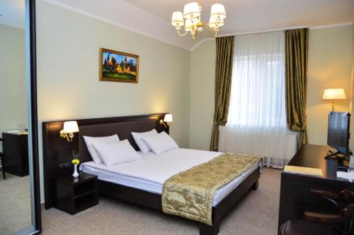 a hotel room with a bed and a mirror at Churchill-Inn in Vinnytsya
