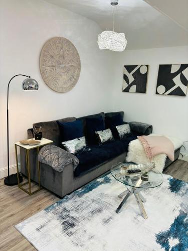 a living room with a couch and a glass table at HERTFORD House with garden parking pet friendly pool room in Hertford
