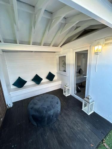a room with a bench with three pillows on it at HERTFORD House with garden parking pet friendly pool room in Hertford
