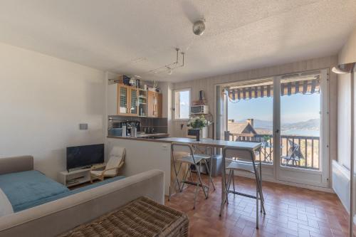 un salon avec un canapé et une cuisine avec une table dans l'établissement Le Chanchore Alpin - Superbe vue montagne, à Saint-Sauveur