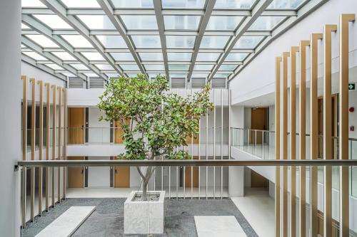 a tree in the middle of a building with a glass ceiling at Hyde Sukhumvit 11 Bangkok in Bangkok