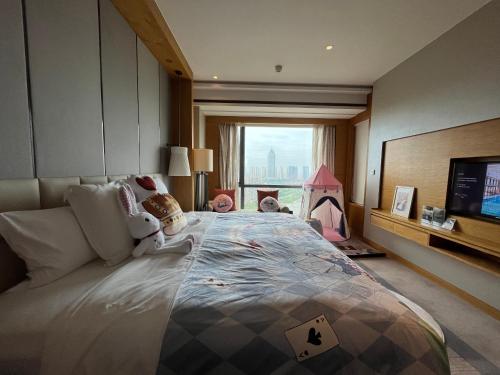 a bedroom with a large bed and a tv at Pullman Haining in Haining