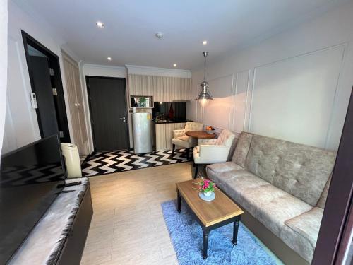a living room with a couch and a table at Venetian Signature Pattaya by รมิตา in Jomtien Beach