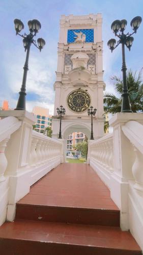 a building with a clock tower with a bridge at Venetian Signature Pattaya by รมิตา in Jomtien Beach