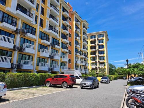 a parking lot with cars parked in front of a building at Venetian Signature Pattaya by รมิตา in Jomtien Beach