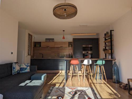 un salon avec un canapé et une cuisine dans l'établissement Magnifique T3 à 50 m du Bassin, à Lanton