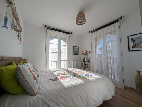 une chambre blanche avec un lit et deux fenêtres dans l'établissement Magnifique T3 à 50 m du Bassin, à Lanton