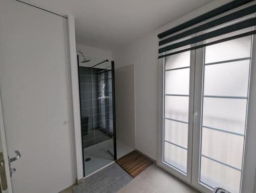 une salle de bain avec douche et porte vitrée dans l'établissement Magnifique T3 à 50 m du Bassin, à Lanton