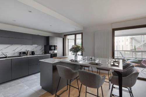 une cuisine avec une table et des chaises dans une cuisine dans l'établissement MDOR - Le Cipriani - Joli T3 avec grande terrasse dans Rennes, à Rennes