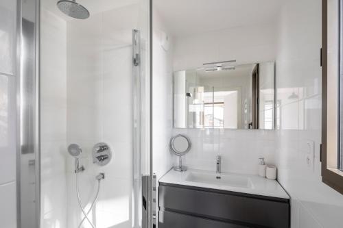 une salle de bain blanche avec un lavabo et un miroir dans l'établissement MDOR - Le Cipriani - Joli T3 avec grande terrasse dans Rennes, à Rennes