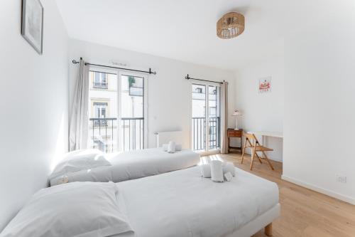 deux lits dans une chambre aux murs blancs dans l'établissement MDOR - Octo Gone, à Lyon