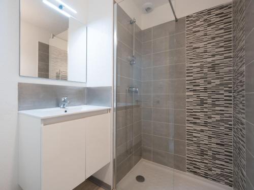 une salle de bain avec une douche avec un lavabo et un miroir dans l'établissement La Dune 20 - Villa 3P4, à Valras-Plage