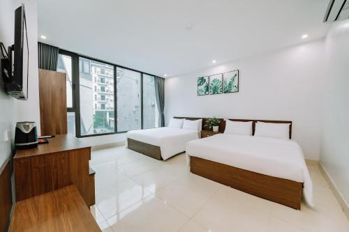 a hotel room with two beds and a television at Cat Ba Friendly Hotel in Cat Ba