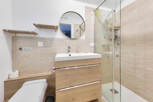 une salle de bain avec toilettes, lavabo et miroir dans l'établissement Maison pour 4 - proche plages et commerces, à La Baule
