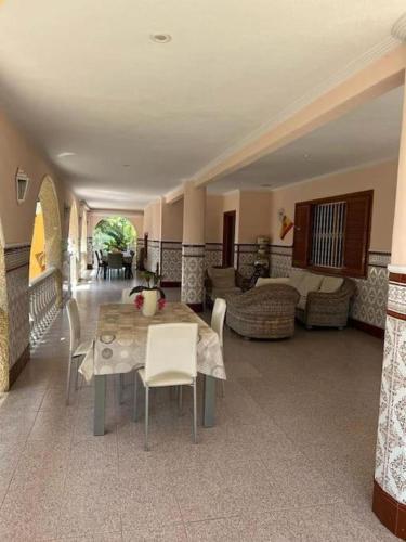 a room with a table and chairs and a living room at Villa Iluminada con chimenea, barbacoa y piscina cerca Playa in Elche