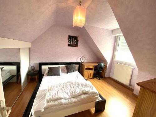 une chambre avec un lit blanc dans un grenier dans l'établissement Maison 5 pièces 6 a 7 personnes à proximité de la plage du Fort-Bloqué - Wi-fi - Maeline, à Ploemeur