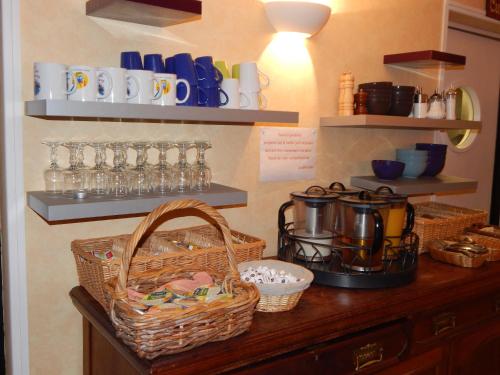 a counter with baskets and cups on a wall at Le Lion D'or in Ouroux en Morvan