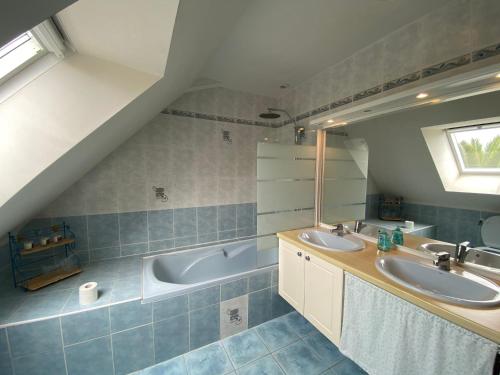 une salle de bain avec deux lavabos et une baignoire dans l'établissement Maison 5 pièces 6 a 7 personnes à proximité de la plage du Fort-Bloqué - Wi-fi - Maeline, à Ploemeur