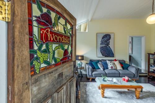 a living room with a couch and a table at Avondale Mountain Cottage in Katoomba