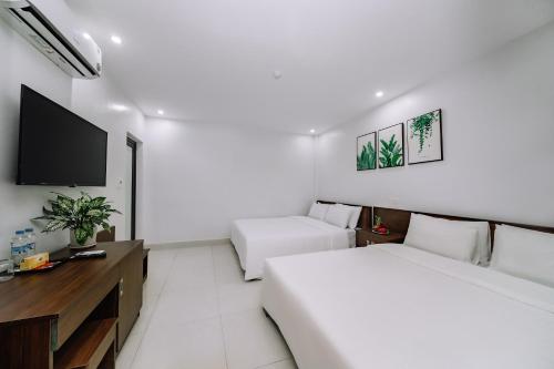 a hotel room with two beds and a flat screen tv at Cat Ba Friendly Hotel in Cat Ba