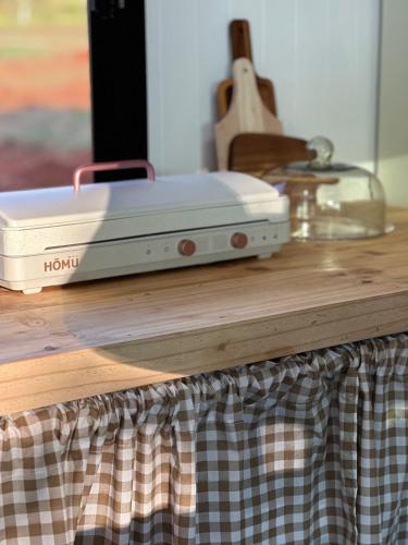 a white toaster sitting on top of a wooden table at Tiny Escape Charlotte in Pak Chong