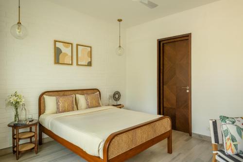 a bedroom with a bed and a wooden door at La Olalian 2 & 3 BHK Designer Villas Near Anjuna Beach with Private Pool & Sun Deck & Garden in Anjuna