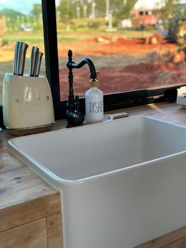 a kitchen counter with a sink next to a window at Tiny Escape Charlotte in Pak Chong