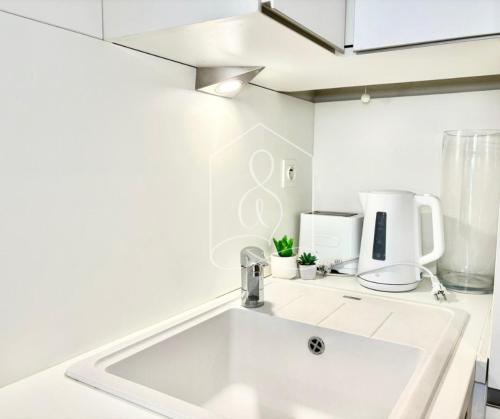 a white kitchen with a sink and a blender at LONDON CANNES, vue mer in Cannes