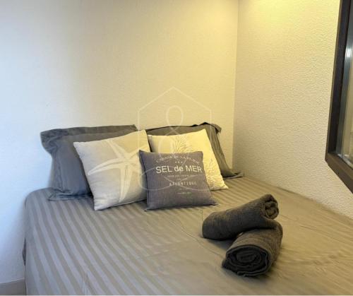 a bed with some pillows and a blanket on it at LONDON CANNES, vue mer in Cannes