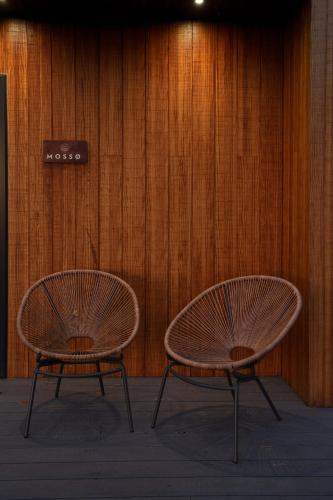 two chairs sitting in front of a wooden wall at Hygge at Vallum in Newcastle upon Tyne