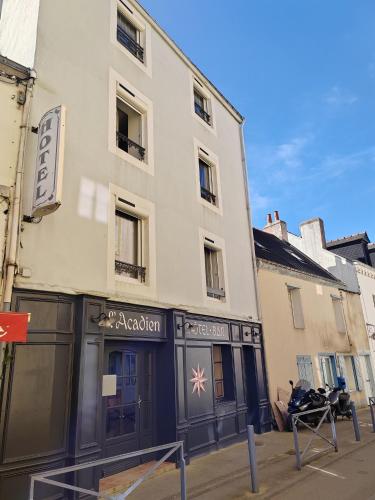 ル・パレにあるHôtel l'Acadienの側面に看板がある白い建物
