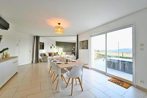 une cuisine et une salle à manger avec une table et des chaises dans l'établissement L'Instant de Sérénité Panorama et Style, à Sevremont