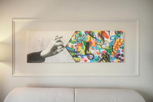 une peinture d'une main sur un costume sur un mur dans l'établissement Le Ray - Parking-2min Mer - VCA, à Cannes