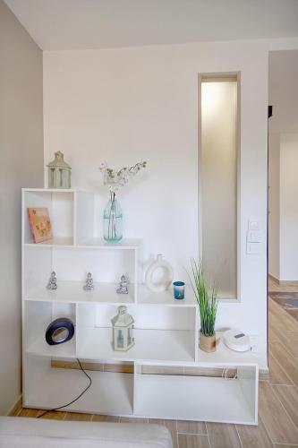 Cette chambre blanche dispose d'étagères blanches et d'un miroir. dans l'établissement Le Ray - Parking-2min Mer - VCA, à Cannes