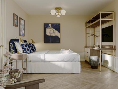 a bedroom with a white bed and a television at Kusthotellet Styrsö in Styrsö