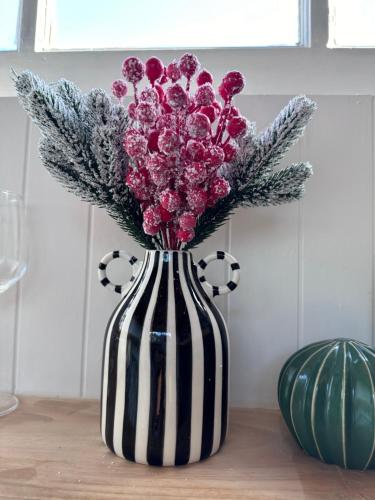a black and white vase with purple flowers in it at Tiny Escape Charlotte in Pak Chong
