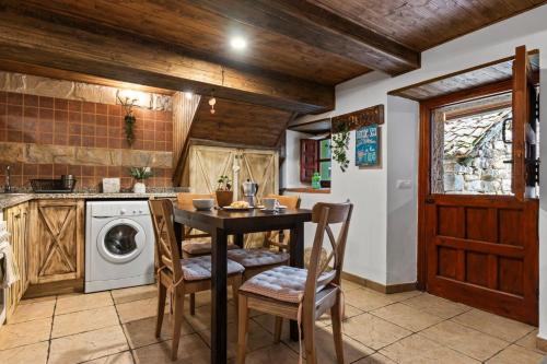 a kitchen with a table and a washing machine at La Congosta, mágica aldea rodeada de montañas in La Plaza
