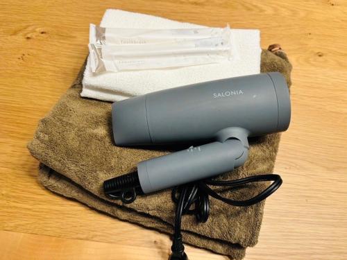 a hair dryer on top of a towel at tsubaki house in Sengendai