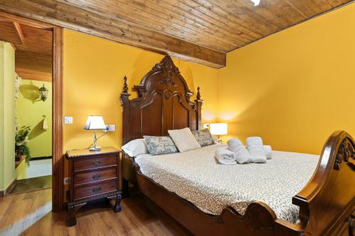 a bedroom with a large bed with a wooden headboard at La Congosta, mágica aldea rodeada de montañas in La Plaza