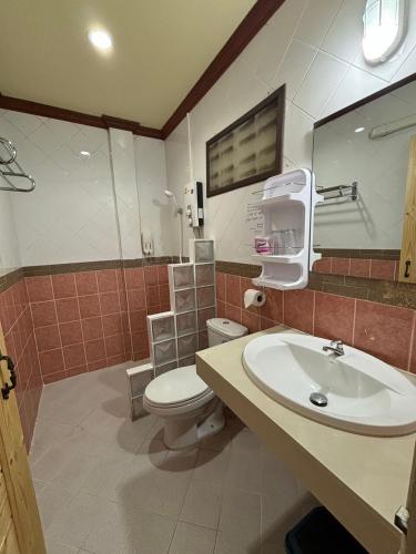 a bathroom with a white toilet and a sink at Rin Bay View Resort in Haad Rin