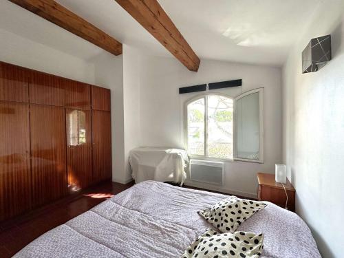 une chambre avec un grand lit et une fenêtre dans l'établissement HYEGRASSE Villa pour 6 personnes à 100 mètres de la plage situé sur le Port d'Hyères, à Hyères