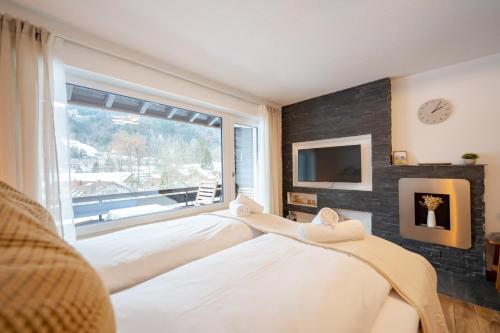 a bedroom with two beds and a large window at Alpenstube mit Bergblick, Sauna und Hallenbad in Oberstdorf