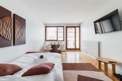 une chambre blanche avec un lit et une table dans l'établissement Appartement Paisible proche parc des princes - 4P - FLAT-GUEST, à Boulogne-Billancourt